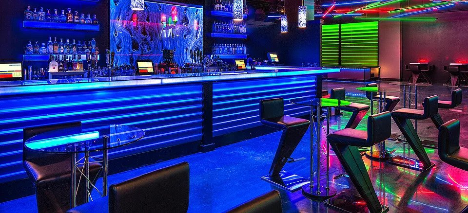 A bar with neon lights and blue lighting.